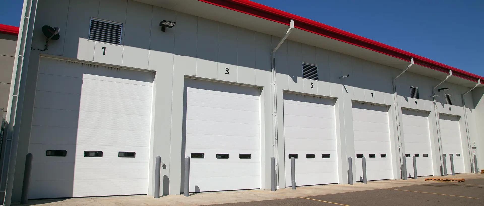 Commercial building with white overhead doors, offering durability for industrial or commercial operations.